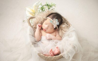 Bébé endormi dans un panier décoré de tulle, fleurs et plumes