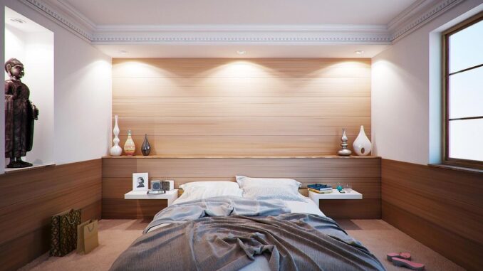 Chambre moderne avec lit, mur bois, étagères, lampes et statue