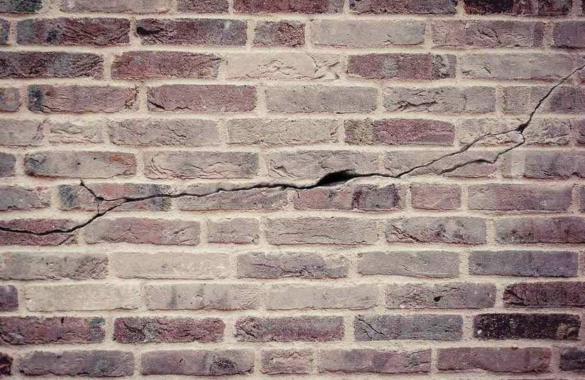 Mur de briques anciennes présentant des fissures et signes d'usure Mur de briques anciennes présentant des fissures et signes d'usure