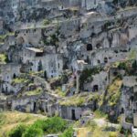 Habitations troglodytes incrustées dans une falaise rocheuse, verdure éparse