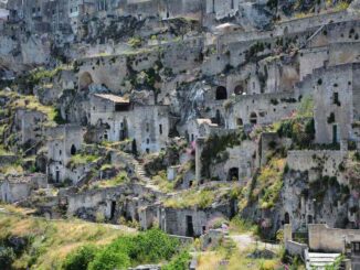 Habitations troglodytes incrustées dans une falaise rocheuse, verdure éparse