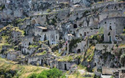 Habitations troglodytes incrustées dans une falaise rocheuse, verdure éparse