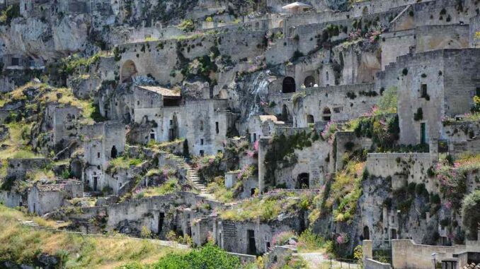 Habitations troglodytes incrustées dans une falaise rocheuse, verdure éparse