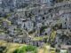 Habitations troglodytes incrustées dans une falaise rocheuse, verdure éparse