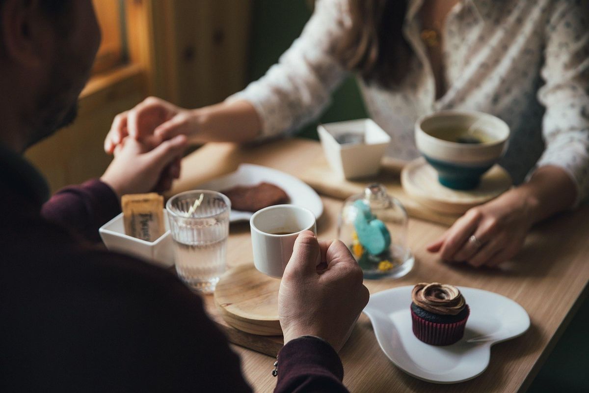 Partage d'un repas entre deux personnes autour d'une table Partage d'un repas entre deux personnes autour d'une table