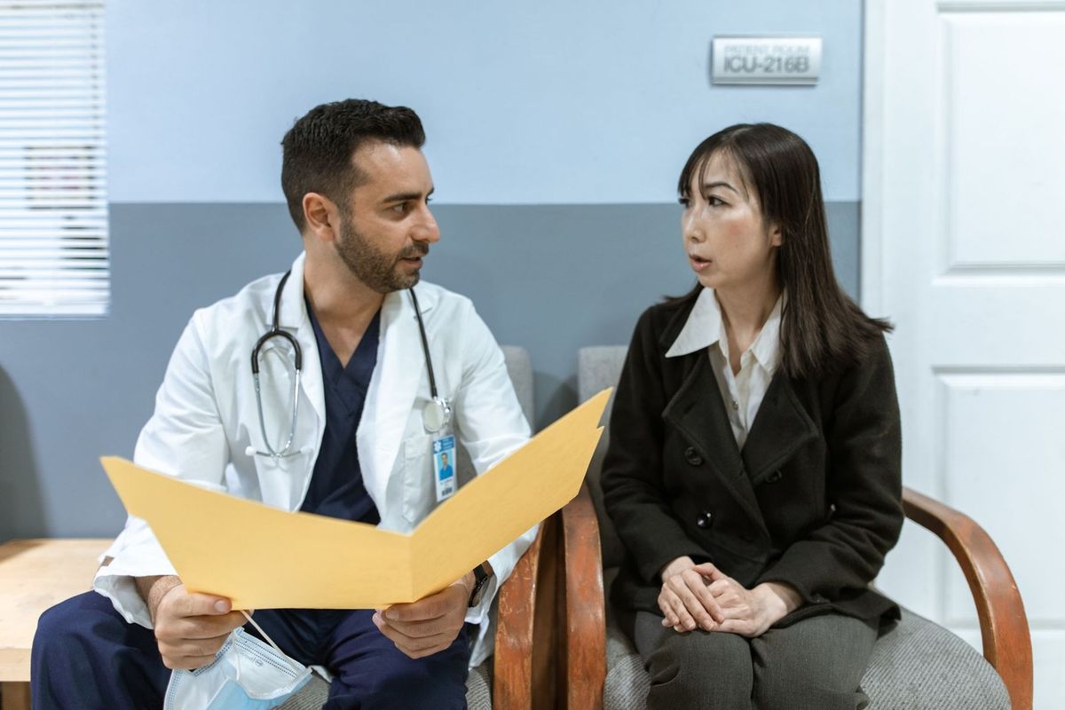 Un médecin et une femme en conversation dans un cabinet médical Un médecin et une femme en conversation dans un cabinet médical